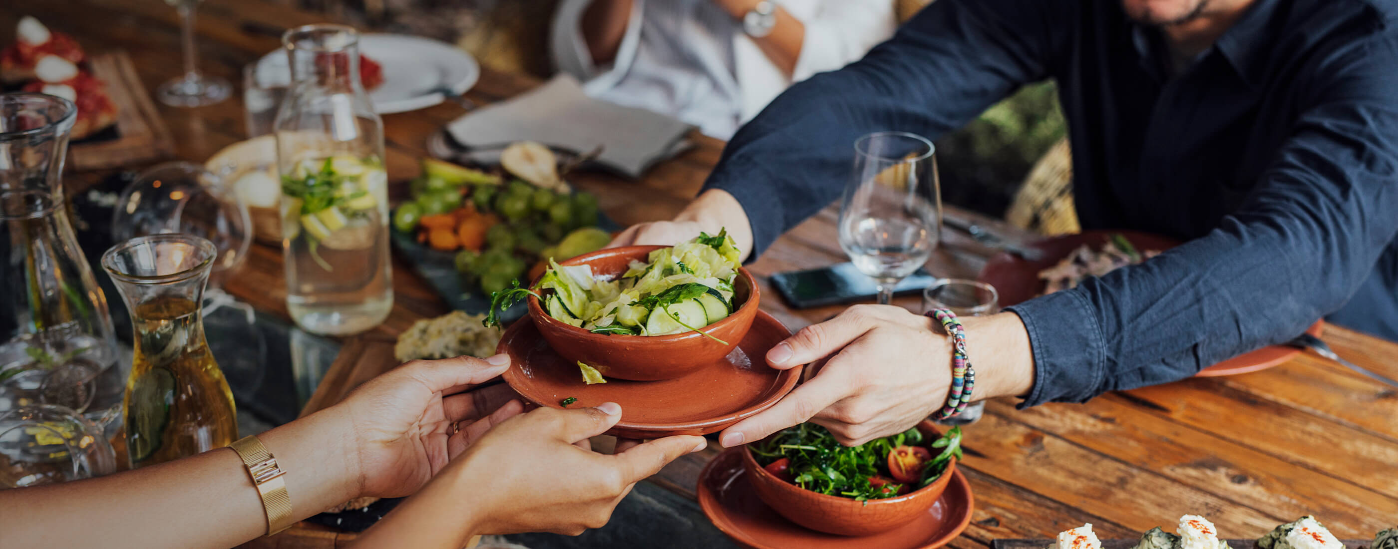 Plate of fresh food being passed across a table